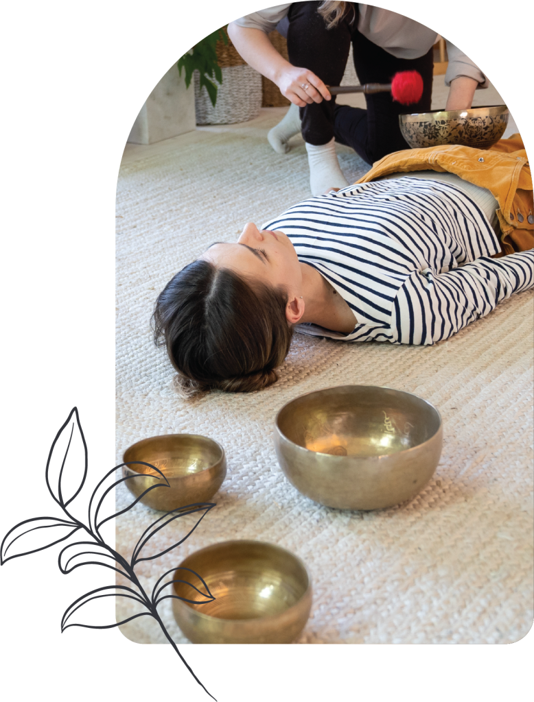 A person lies on a carpeted floor with eyes closed, next to three brass singing bowls. Another holds a mallet over a singing bowl, suggesting sound healing or meditation—one of several Additional Offerings. A simple plant illustration decorates the corner.